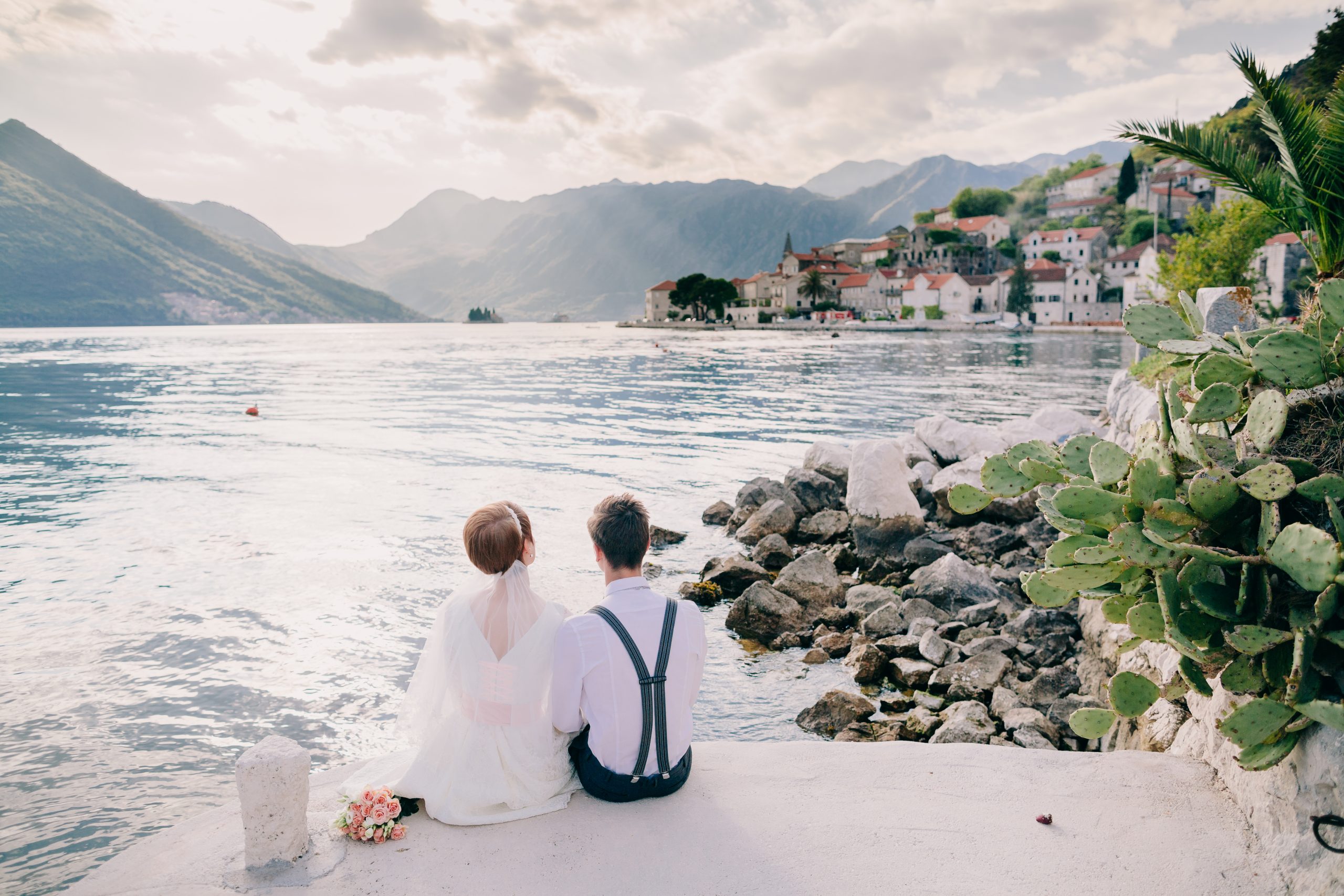 paar sitzt auf dem Steg und schaut auf das kroatische meer
