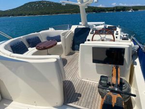 Rudergerät nahaufnahme auf der Flybridge im hintergrund steuerstand, große Eckbank und das Meer