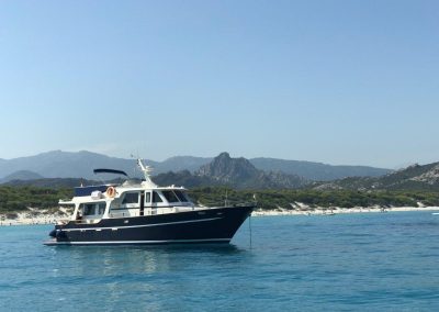 Das Boot Thor liegt vor einem Strand in Korsika