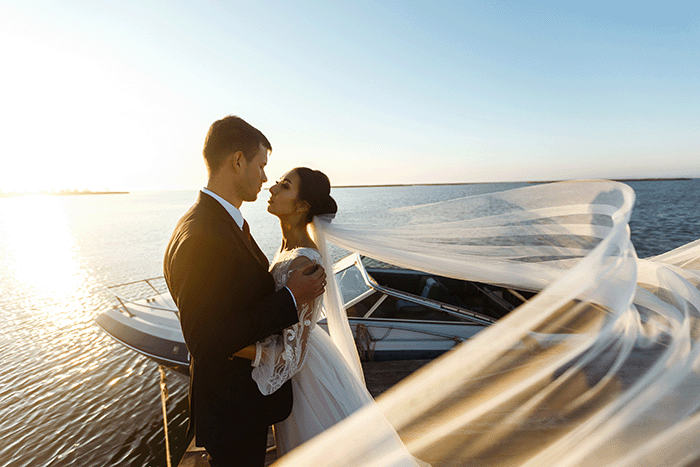 junges ehepaar küsst sich um die heirat auf dem boot zu besiegeln